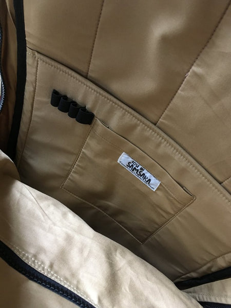 Fair trade, eco friendly, vegan backpack showing the inside view. There are multiple fabric pockets in cream material and a row of four black elastic pen loops