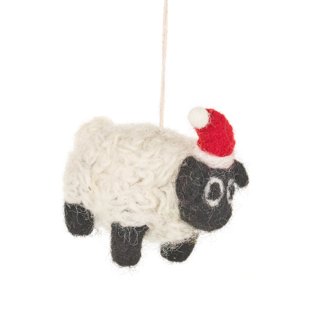 White felt sheep decoration with black legs and face and a red Santa hat