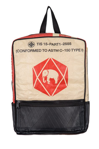 Fair trade, eco friendly, vegan backpack viewed from the front. The main panel is a red and cream cement bag with an elephant logo and the bottom is black recycled tyres. There is a front zip pocket and a black hanging strap